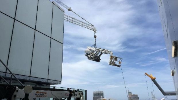 A crawler access platform lift is dangling at 51 stories over Sydney Building after roof mounted derrick crane buckles