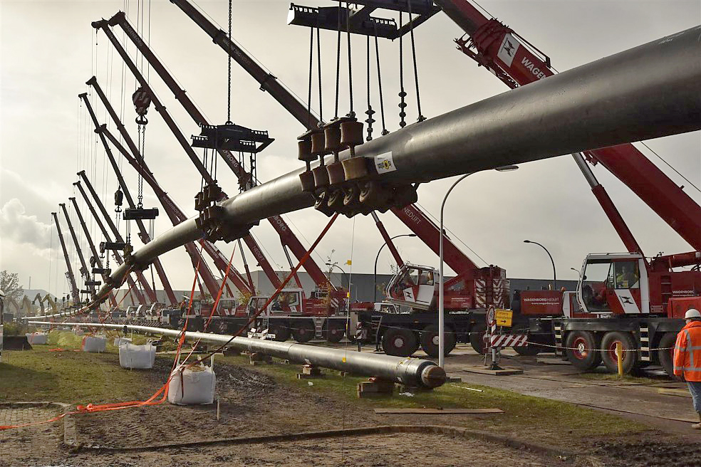 14 Wagenborg All Terrain Cranes line up to lift up two pipes that will run under a canal in the Netherlands