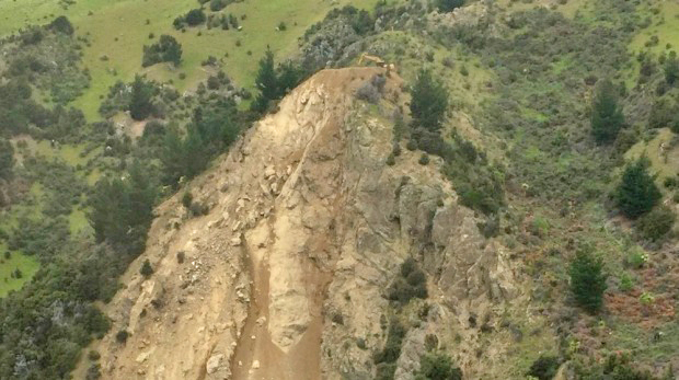 Spotted-a CAT Excavator atop a rock slide to repair severed road in New Zealand